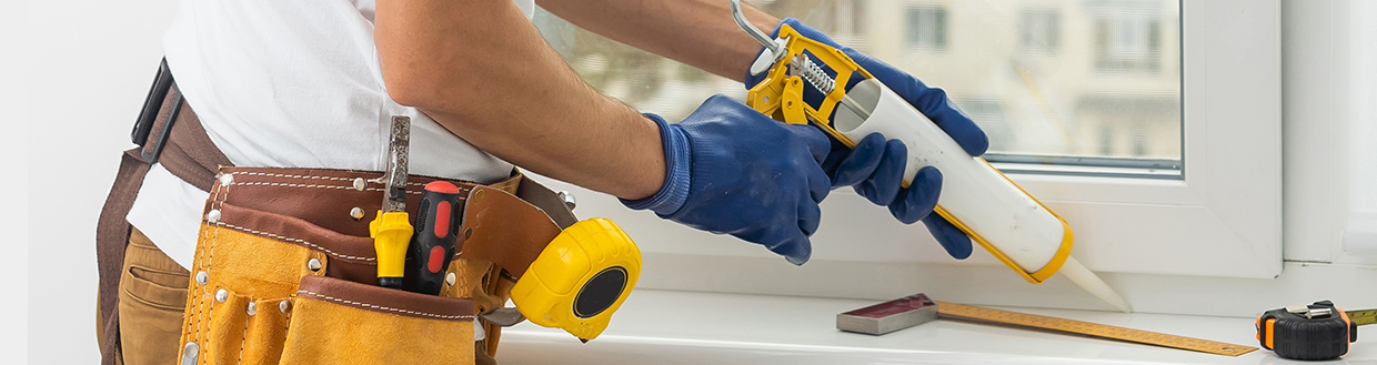 Auftragen von Dichtstoff am Fenster